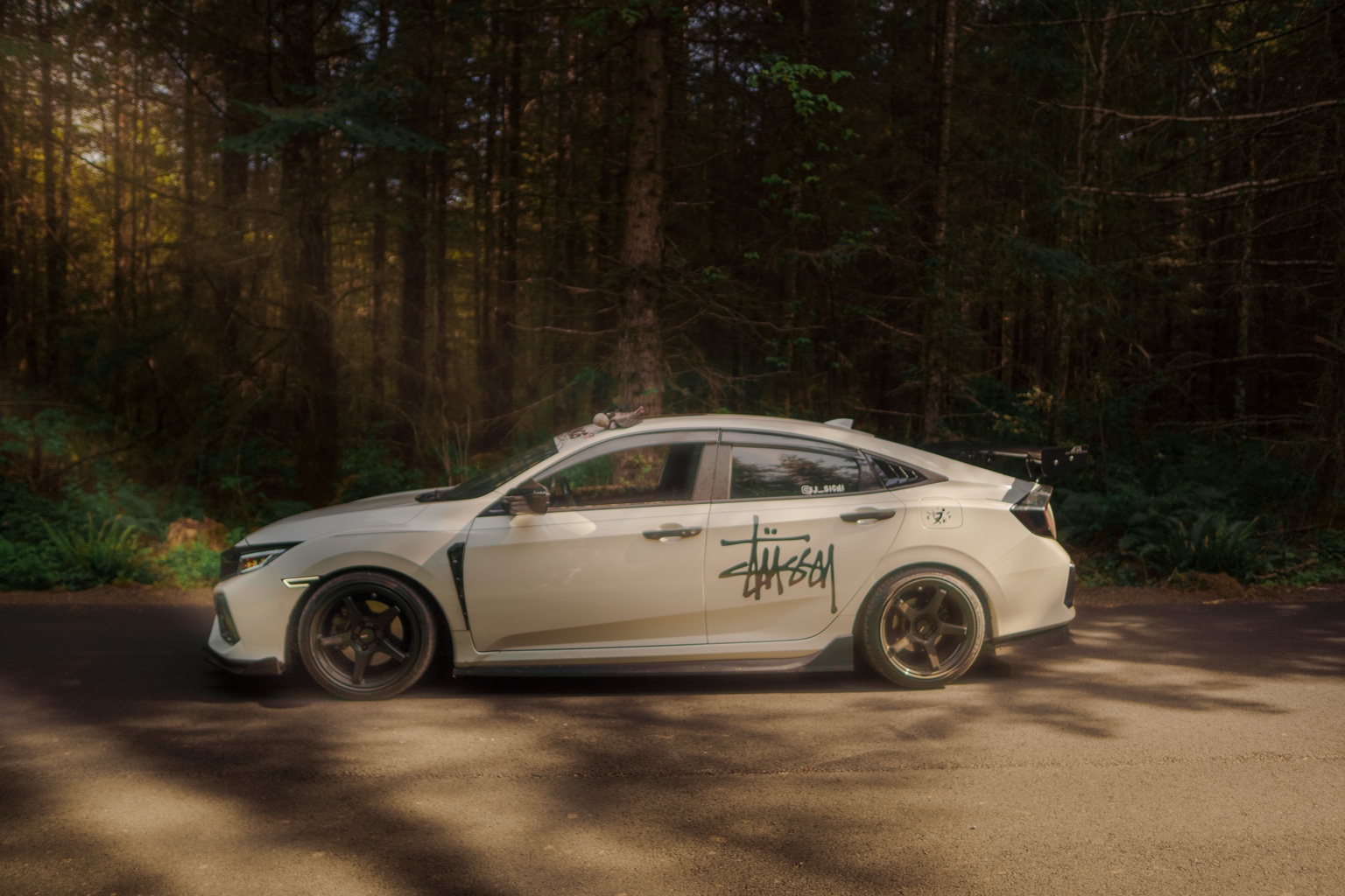 White Honda Civic Si parked in a forest